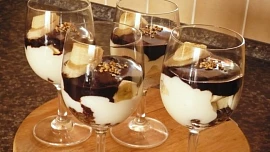 Pohár s banánem a čokoládou nezevšední. Mleté oříšky a strouhaná čokoláda na dně sklenice dodají jiný rozměr chuti