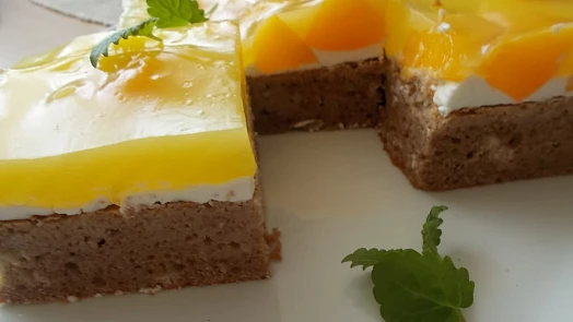 Fantastický moučník s ovocem je báječně vláčný díky tvarohu. Želé z broskvové šťávy mu dodá skvělou svěžest