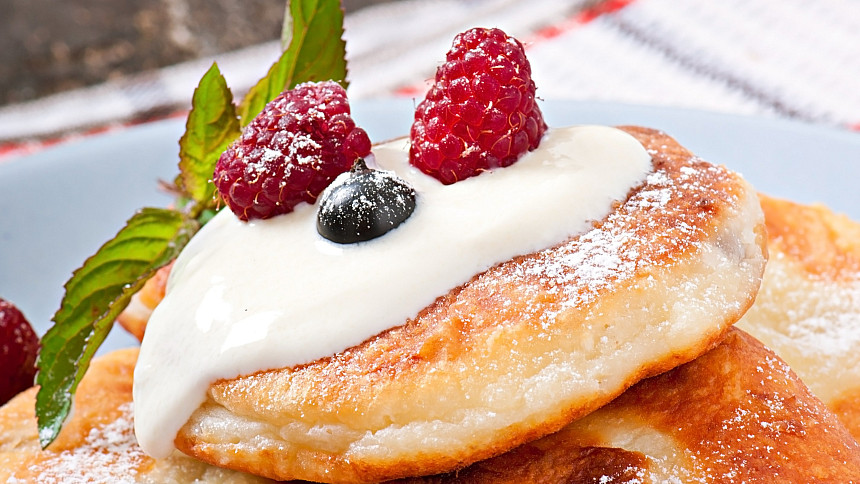 Syrniki se zakysanou smetanou ozdobené bobulovým ovocem