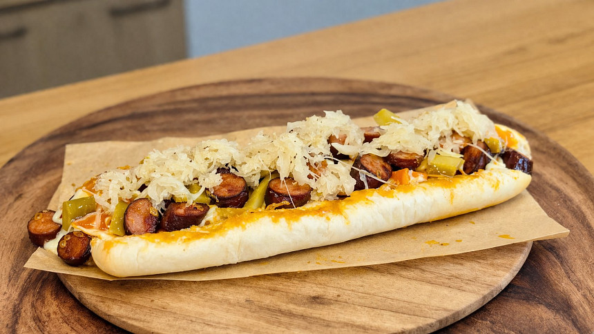 Vynikající hot dog se sýrem, zelím a pivní omáčkou si snadno připravíte doma.