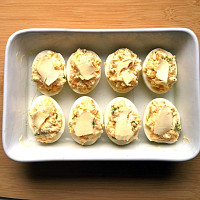 Před upečením se vejce polijí trochou smetany a pokladou plátky másla. Foto: Toprecepty, Pavla Šmikmátorová