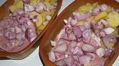 Uzená krkovice zapečená, maso s brambory a cibulí před pečením