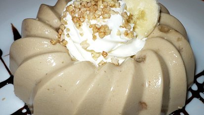 Nepečený vanilkovo-cappuccinový Amaroun s tvarohem, Děláno v jednoporcové bábovičce. Na dozdobení použitý topping,šlehačka, banán a s cukrem opražené sekané mandle