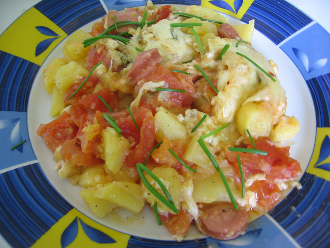 Zapečené brambory s rajčaty a sýrem, ozdobené pažitkou :)