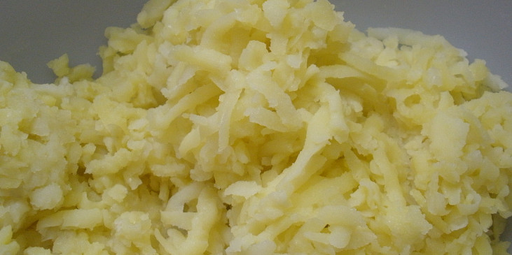 nastrouhané uvařené brambory na hrubém struhadle