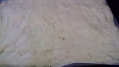Jihočeský kynutý koláč, namáčíme si ruce a těsto roztáhneme po celém plechu...