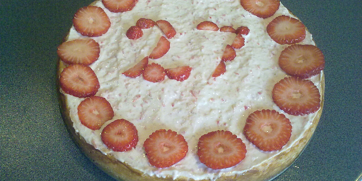 Cheesecake (V zakysance nahoře jsou nastrouhané jahody a…)