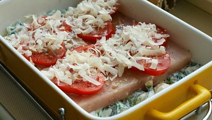 Rybí filé na špenátosýrovém lůžku s rajčatovou čepicí, před vložením do trouby