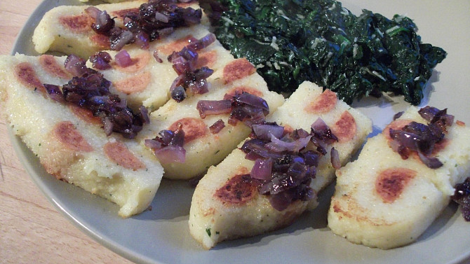 Plněná polenta, podávané s čerstvým spařeným špenátem na česneku a smaženou cibulkou