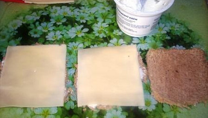 Jednohubky z toastového chleba, vložíme plátky sýru a znovu pomažeme