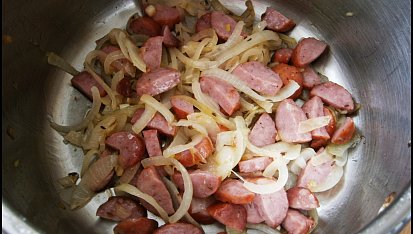 Brambory s uzeninou z papiňáku, V hrnci orestujeme cibuli,přidáme uzeninu a osmahneme.