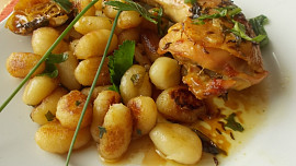 Pečená kuřecí stehna s rukolovým olejem, uzeným česnekem a restovaným gnocchi