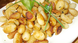 Pečená kuřecí stehna s rukolovým olejem, uzeným česnekem a restovaným gnocchi