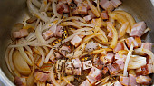 Kuřecí žaludky na pórku,připravené v papiňáku, Do hrnce na tuk a šťávu po klobáse dáme slaninu společně s cibulí a kmínem a přibližně 5minut restujeme, než cibule mírně zavadne.