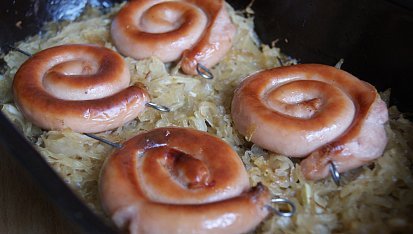 Vinná klobása pečená na zelí s karamelizovanou cibulkou
