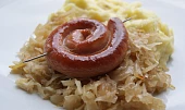 Vinná klobása pečená na zelí s karamelizovanou cibulkou