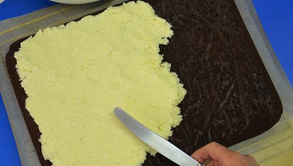 Dvoubarevné kokosové řezy s tuzemákem, . Hutnou bílou náplň rozložte na ještě teplý tmavý plát a prsty ji přitlačte, aby se spojila s podkladem