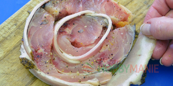 3. Postupně po obvodu přikládejte rybí proužky proložené slaninou. Stočený biftek nakonec oviňte dalšími proužky slaniny