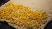 Špaldové kapsy se šunkou a sýrem, Polovinu těsta posypeme sýrem