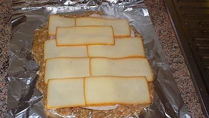 Zarolovaná sekaná se šunkou, sýrem a slaninou, Maso naložíme na alobal, upravíme, poklademe šunkou a sýrem. Já jsem použila uzené plátky
