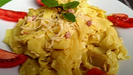 Široké nudle se strouhanou mozzarellou,  čedarem a  vyškvařenou klobáskou
