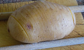 Plněné pečené brambory s kuřecím řízkem (Syrový brambor nakrájíme, ale dáváme pozor, abychom nedokrojili až dolů)