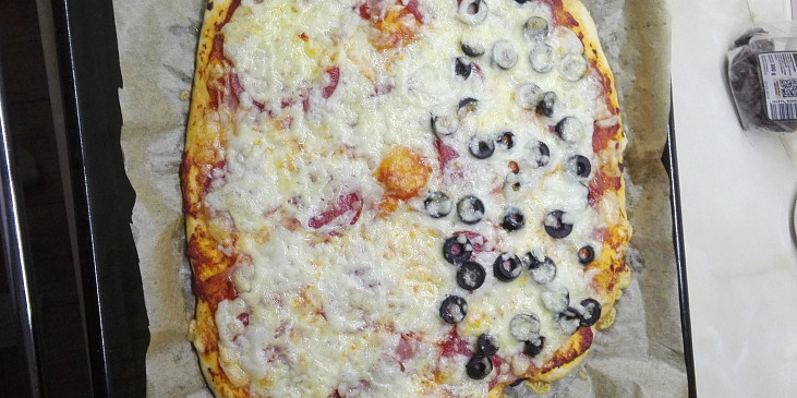 Pizza se šunkou, salámem, třemi druhy sýra a olivami.