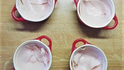 Zapečené vejce se šunkou, sýrem a rajčetem, Mističky vymažeme máslem a vyložíme plátkem šunky. 
