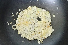 V hluboké pánvi (wok) rozpálíme trochu oleje, na kterém osmahneme cibuli.