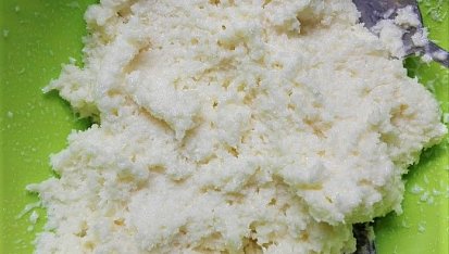 Kokosové kuličky - nepečené, Přisypáváme kokos, dokud nemáme požadovanou konzistenci (necelých 200 g). Lžičkou nabereme směs a rukama uválíme kuličku. 