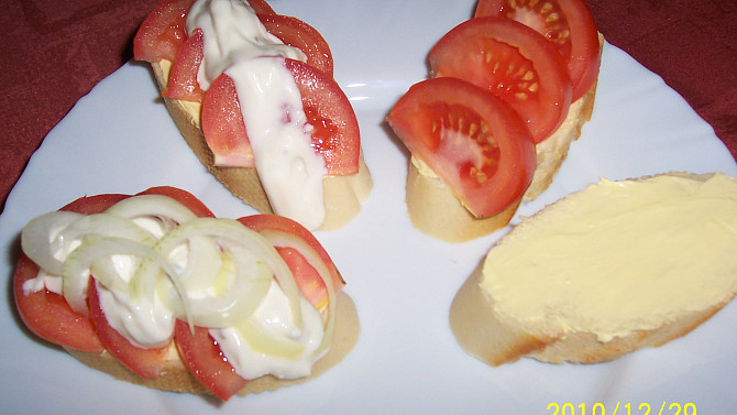Chlebíčky s rajčaty a cibulí, plátky veky namazat máslem, poklást rajčaty, polít tatarkou, ozdobit cibulí