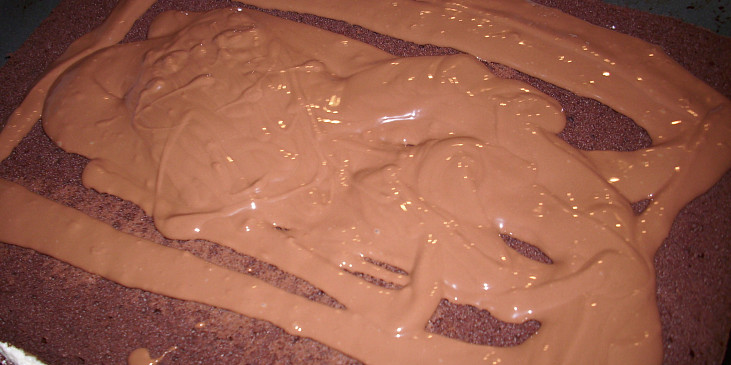 Zdobení čokoládovou polevou (1. Na vychladlý korpus naneseme základní polevu …)