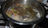 Polévka z kachních krků a králíčích polévkových dílů s česnekovozázvorovým kapáním (maso a koření v hrnci)