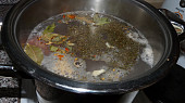 Polévka z kachních krků a králíčích polévkových dílů s česnekovozázvorovým kapáním, maso a koření v hrnci