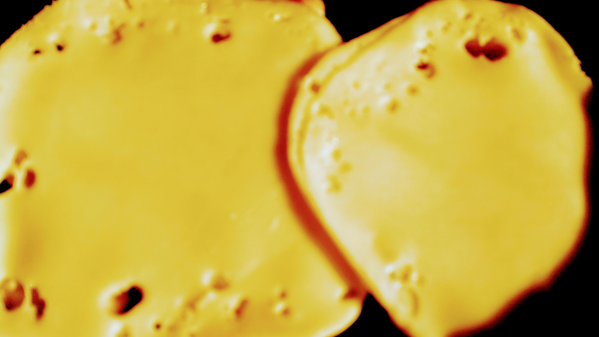 Načesnekované maso schované pod dvojitým plátkem sýru před pečením. 