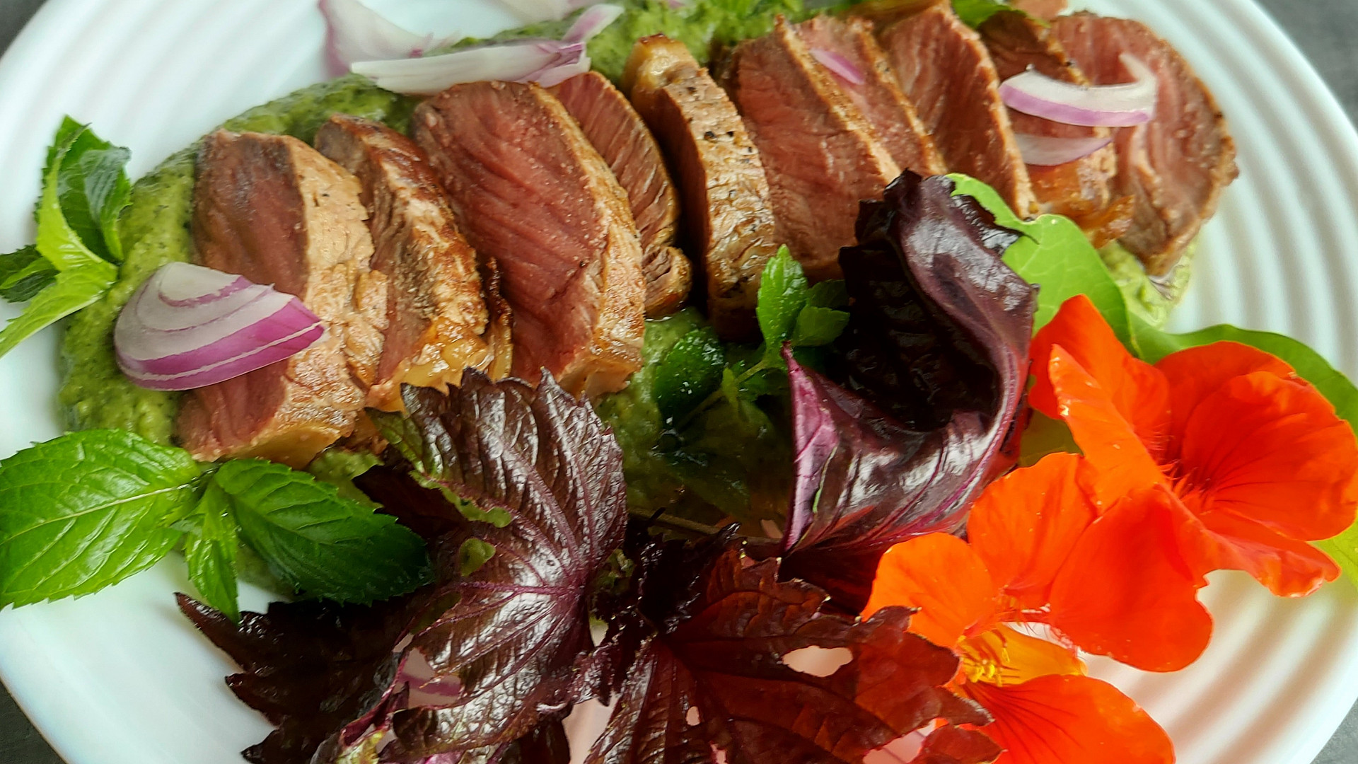 Striploin steak s mátovo hráškovým pyré, bylinkami a jedlými květy