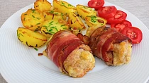 Válečky z mletého kuřecího masa obalené slaninou a pečené brambory s česnekem.