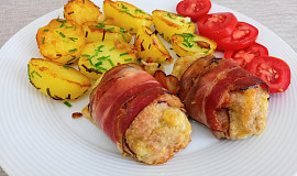 Válečky z mletého kuřecího masa obalené slaninou a pečené brambory s česnekem.