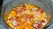 Válečky z mletého kuřecího masa obalené slaninou a pečené brambory s česnekem.