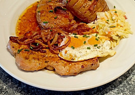 Vepřový steak z kotlety se smaženou cibulí a sazeným vejcem