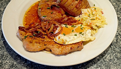 Vepřový steak z kotlety se smaženou cibulí a sazeným vejcem
