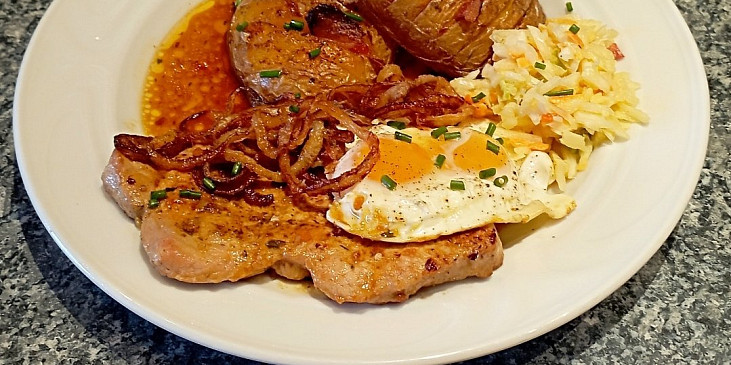 Vepřový steak z kotlety se smaženou cibulí a sazeným vejcem