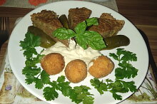 Servírování s bramborovými kroketami troškou tatarky a kyselou okurkou